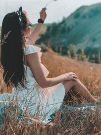 Side view of woman relaxing on field