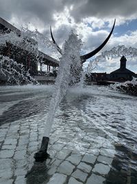 Water splashing in fountain against sky during winter