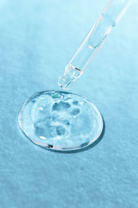 Hyaluronic gel on a blue background with a glass pipette close-up. cosmetic product 