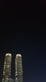 Low angle view of illuminated buildings against sky at night