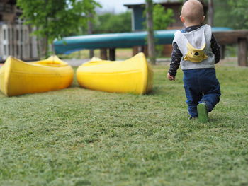 Rear view of baby boy walking at park