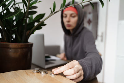 Portrait of young woman standing by plants