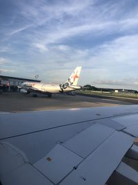 Airplane on runway against sky