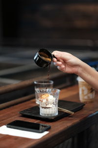 Midsection of person pouring drink in glass