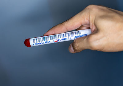 Close-up of hand holding sign against blue background