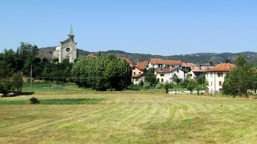 View of buildings against clear blue sky