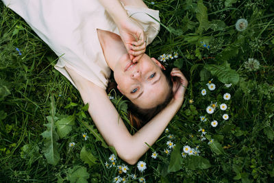 High angle view of young woman lying on grass