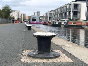 View of street by canal against sky