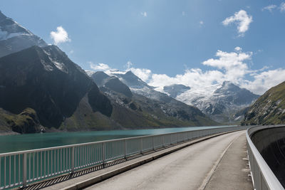 Road leading towards mountains against sky