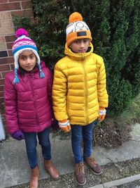 Portrait of siblings standing in snow