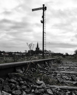 Railroad tracks on field against sky