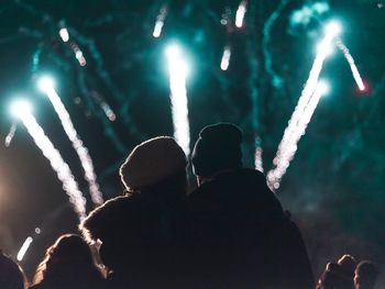 Rear view of couple looking at firework display