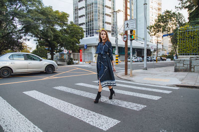 Full length of woman crossing road