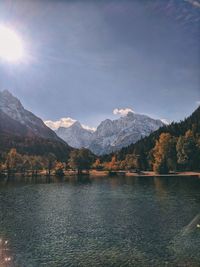 Scenic view of lake by mountains against sky