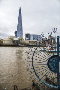 Building by river against sky in city