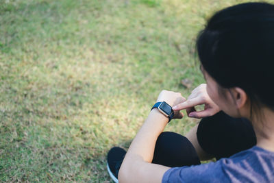 High angle view of woman using smart watch in grass