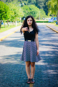 Teenage girl standing on footpath at park
