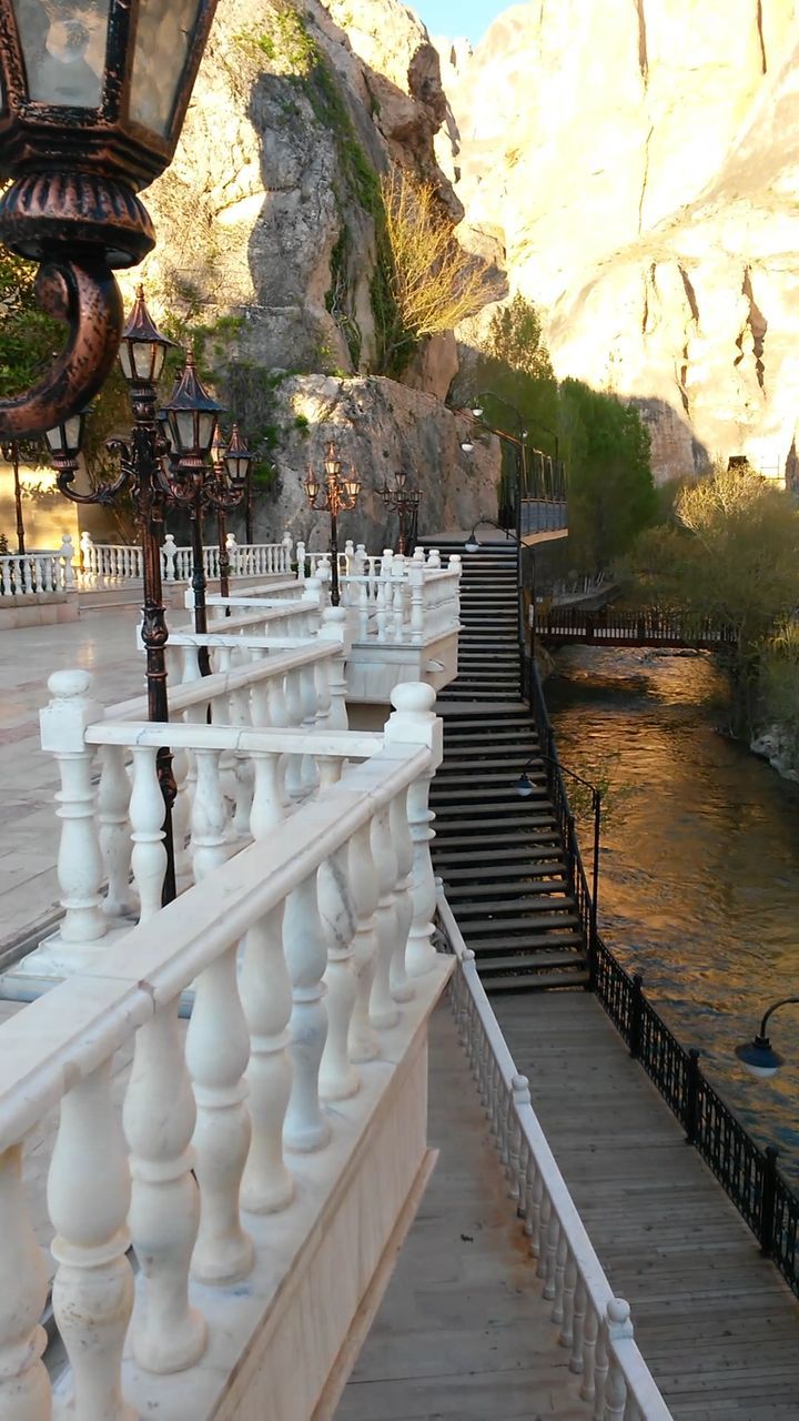 the way forward, railing, water, built structure, steps, diminishing perspective, footbridge, architecture, pier, steps and staircases, vanishing point, connection, sunlight, bridge - man made structure, shadow, tree, boardwalk, nature, walkway, incidental people