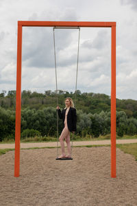 Woman sitting on swing at playground