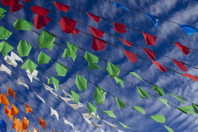 Low angle view of decoration flags against cloudy sky