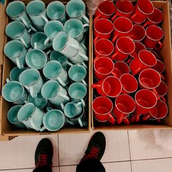 Low section of man standing by cups in container
