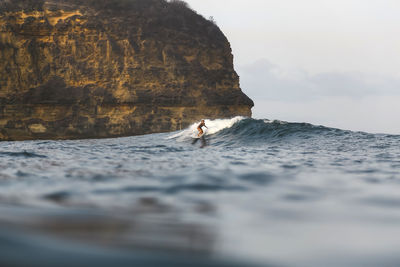 Young woman surfing in indian ocean