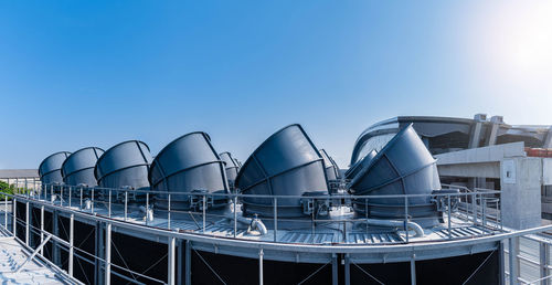 Low angle view of industry against clear blue sky