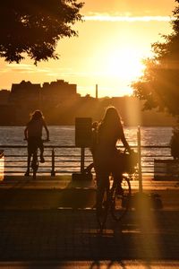 Silhouette of people on pier at sunset