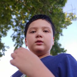 Low angle portrait of boy standing in park