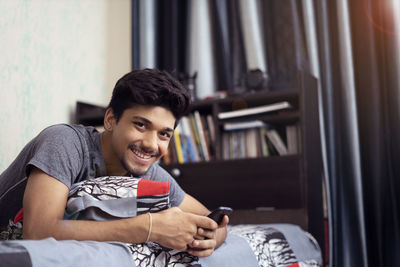 Young man using mobile phone at home