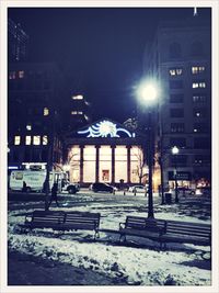 Snow covered road in city at night