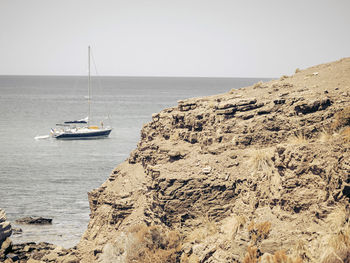 Sailboat sailing on sea against clear sky