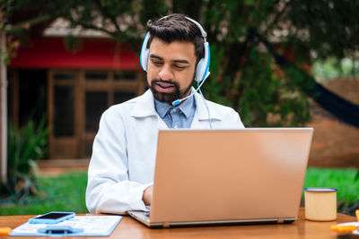 Businesswoman using laptop while sitting on table