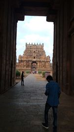 Rear view of people in front of temple