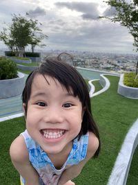 Portrait of smiling girl against sky