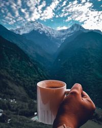 Close-up of hand holding coffee cup