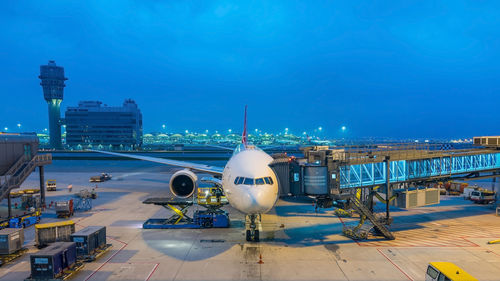 Airplane on airport runway against sky