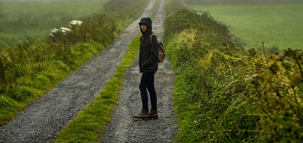 Rear view of woman walking on field