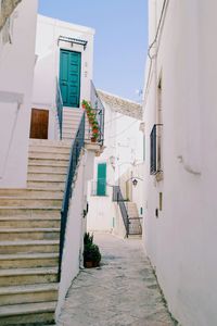 Alley amidst houses against sky