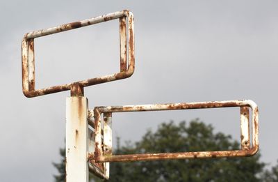 Low angle view of rusty metallic pole against clear sky