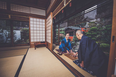 Rear view of people sitting outside temple