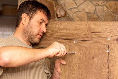 Midsection of man making face on wood