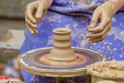 Midsection of woman making clay pot