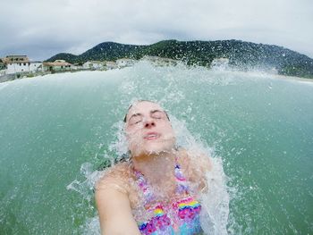 Woman swimming in sea against sky