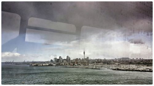View of cityscape against cloudy sky