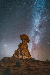 Balanced rock standing strong against milkyway night sky at night in arches national park moab utah.