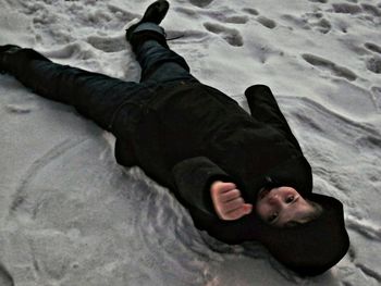 Low section of child lying on sand