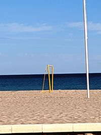 Lifeguard hut on beach against blue sky