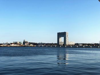 River in city against clear blue sky