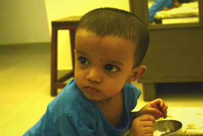 Close-up portrait of cute boy eating food at home